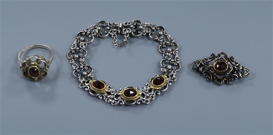 A garnet set white metal bracelet, ring and brooch.